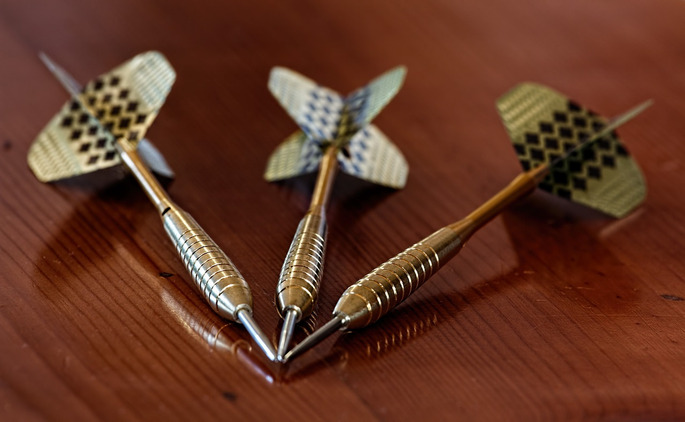 Gold Darts on Wooden Table