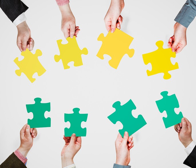 Business People Holding Yellow and Green Puzzle Pieces