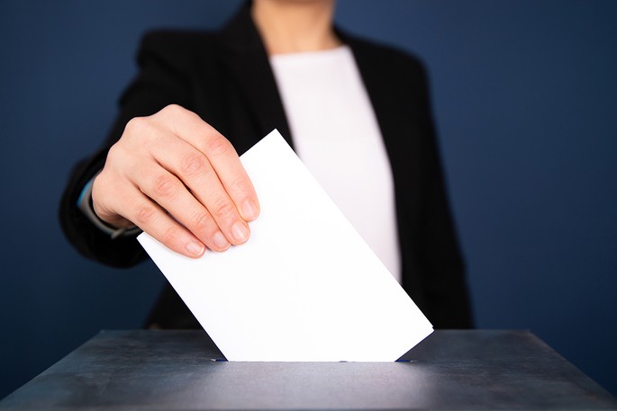 Businesswoman Placing Vote in Ballot Box
