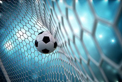 Football Against Net with Lights in Background