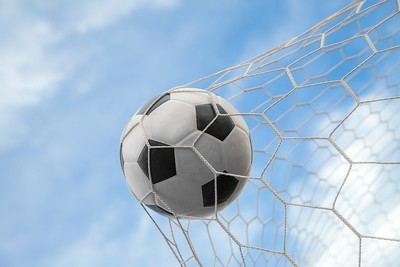 Football Hitting Net Against Blue Sky