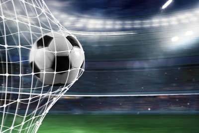 Football Hitting Net Against Blurred Stadium