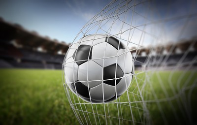 Football Hitting Net Against Stadium