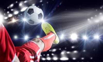 Footballer in Red Kicking Ball