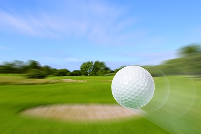 Golf Ball Flying Over Blurred Course