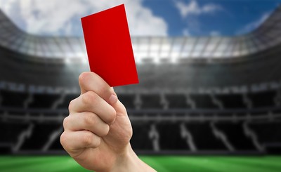 Hand Holding Up Red Card in Large Stadium