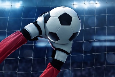 Hands of Goalkeeper Saving Ball Against Floodlights