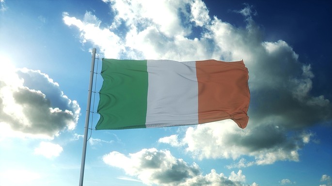 Ireland Flag Against Bright Cloudy Blue Sky