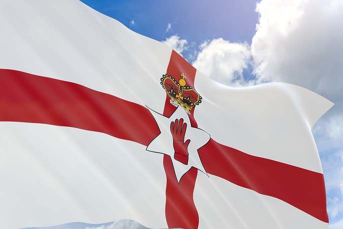 Northern Ireland Flag Against Bright Blue Cloudy Sky
