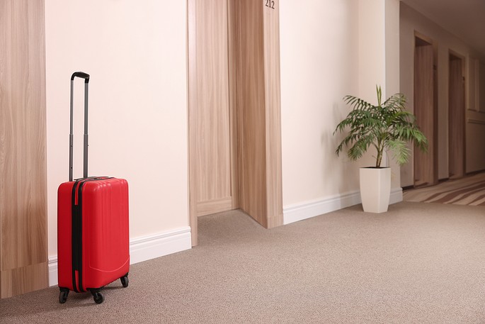 Red Suitcase in Hotel Corridor